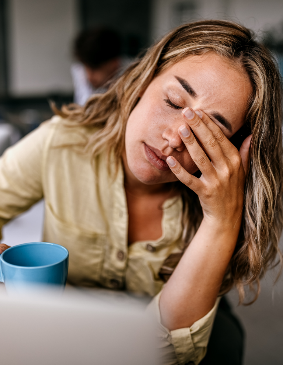 Frau fasst sich aufgrund von störenden Ohrgeräuschen an den Kopf.